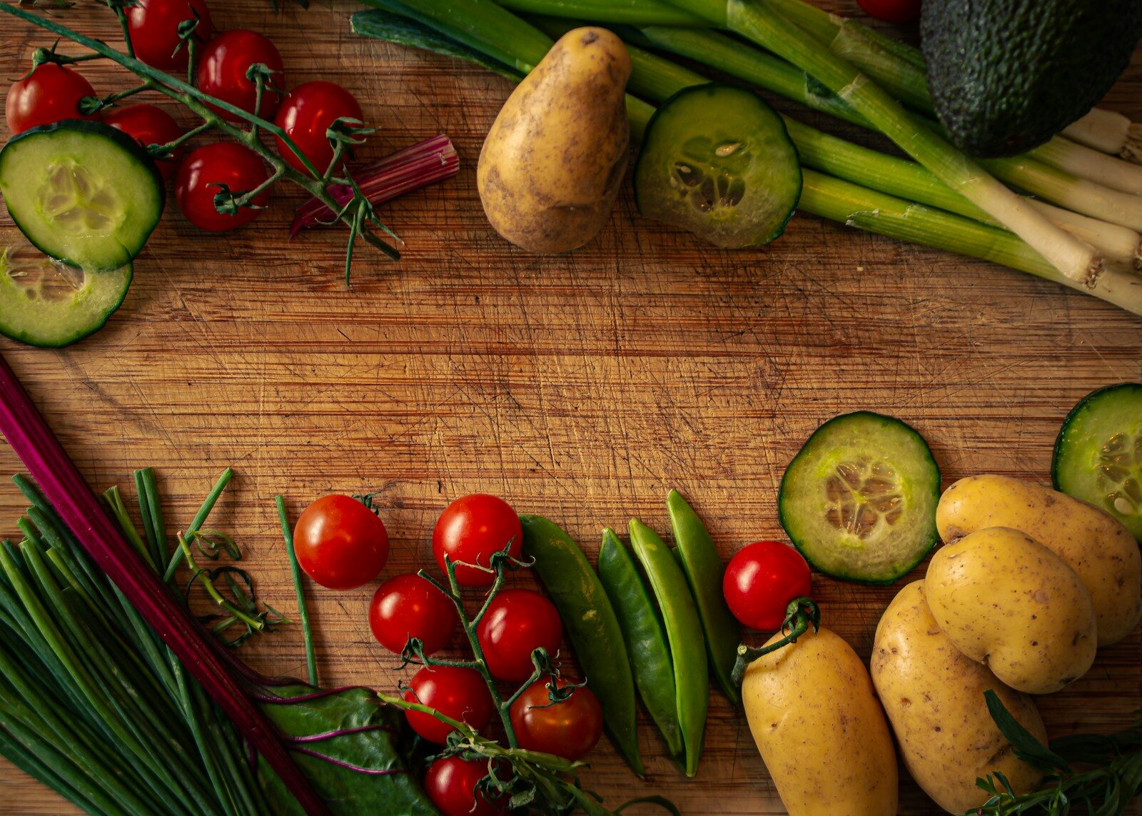 a wooden cutting board topped with lots of veggies